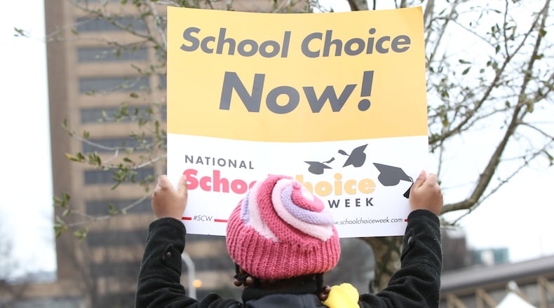 A school choice supporter holds a sign at a rally at the state Capitol. TAYLOR.CARPENTER@AJC.com