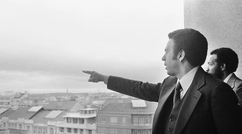 Andrew Young, left, U.S. ambassador to the United Nations, and his aide, Stoney Cooks, right, look over the skyline of Lisbon, Sunday, May 15, 1977, from vantage point on the roof of a city hotel. (AP Photo)