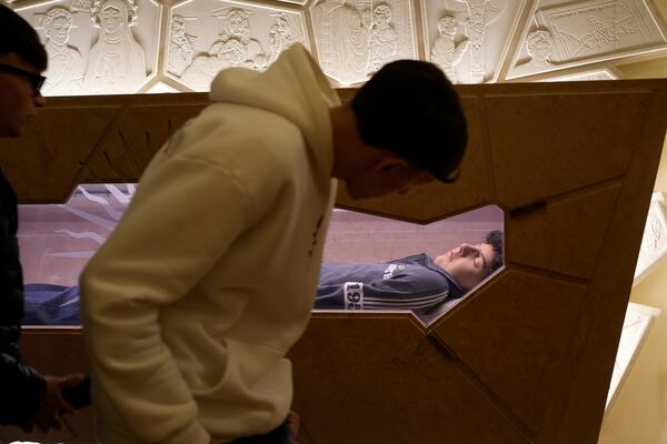 The body of Carlo Acutis, an Italian boy who died in 2006 of leukemia, lies in his tomb in Assisi, Italy, on Saturday, March 1, 2025. (AP Photo/Gregorio Borgia)