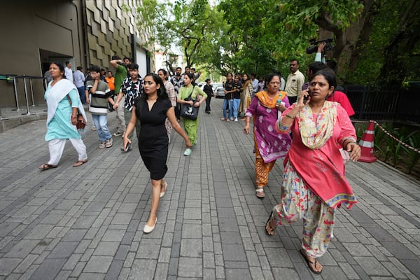 People rush to a safe place during a security mock drill at a mall in Ahmedabad, India, Wednesday, May 7, 2025, amid rising fears of wider conflict following India's strikes in Pakistan. (AP Photo/Ajit Solanki)