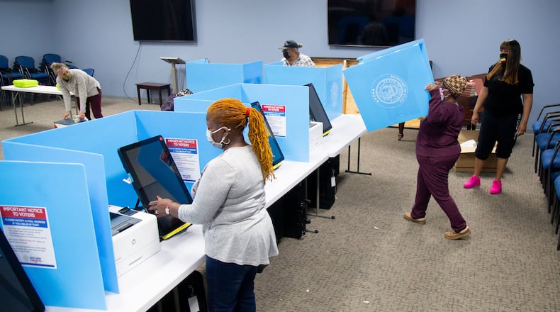Poll workers set up the Briarlake Baptist Church polling center in preparation for an election. STEVE SCHAEFER / SPECIAL TO THE AJC