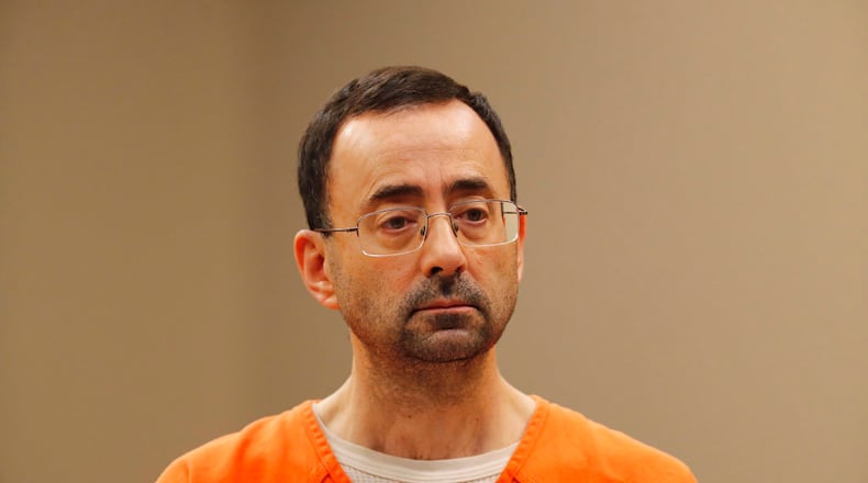 FILE - In this Nov. 22, 2017, file photo, Dr. Larry Nassar, appears in court for a plea hearing in Lansing, Mich. Nassar, an elite Michigan sports doctor who possessed child pornography and assaulted gymnasts, was sentenced Thursday, Dec. 7, 2017,  to 60 years in federal prison in one of three criminal cases that ensure he will never be free again. (AP Photo/Paul Sancya, File)