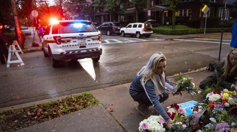 People place flowers near the Tree of Life Congregation, a day after 11 people died at the synagogue during a shooting rampage in Pittsburgh, Oct. 28, 2018. Georgia is one of 4 states without a hate crimes law. (Michael Henninger/The New York Times)