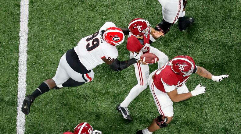 Georgia Bulldogs defensive lineman Jordan Davis (99) strips the ball from Alabama Crimson Tide quarterback Bryce Young (9) in the first quarter. Georgia recovered and appeared to score, but it was ruled an incomplete pass, at the 2022 College Football Playoff National Championship between the Georgia Bulldogs and the Alabama Crimson Tide at Lucas Oil Stadium in Indianapolis on Monday, Jan. 10, 2022. (Bob Andres/The Atlanta Journal-Constitution/TNS)
