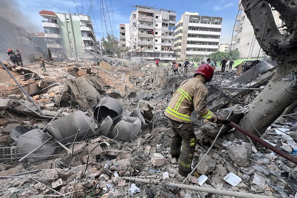 Firemen work on the site of an Israeli army strike in the suburb of Dahiye, Beirut, Friday March 28, 2025.(AP Photo/Hussein Malla)