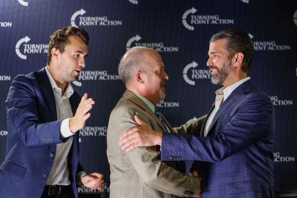 Former Wisconsin Attorney General and state Supreme Court candidate Brad Schimel, middle, greets Donald Trump Jr., as Charlie Kirk looks on during a town hall Monday, March 17, 2025, in Oconomowoc, Wis. (AP Photo/Jeffrey Phelps)