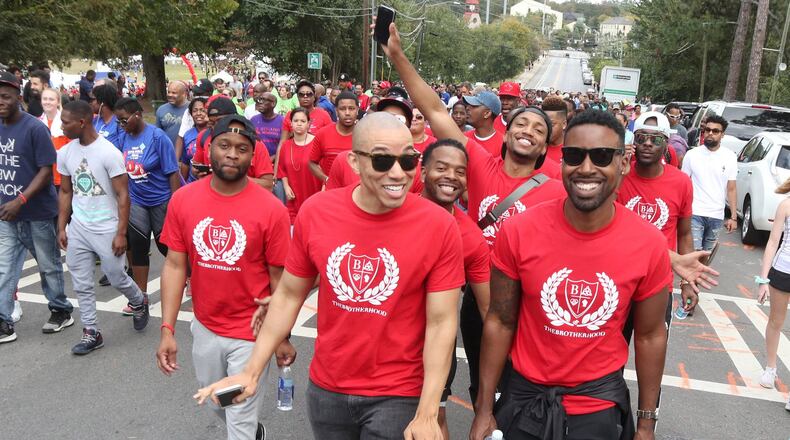 Rolondo Brown and Ashad Wood walk up 10th Street for the beginning of the 27th Annual AIDS, and 5K Run Sunday at Piedmont Park in Atlanta GA October 22, 2017. STEVE SCHAEFER / SPECIAL TO THE AJC