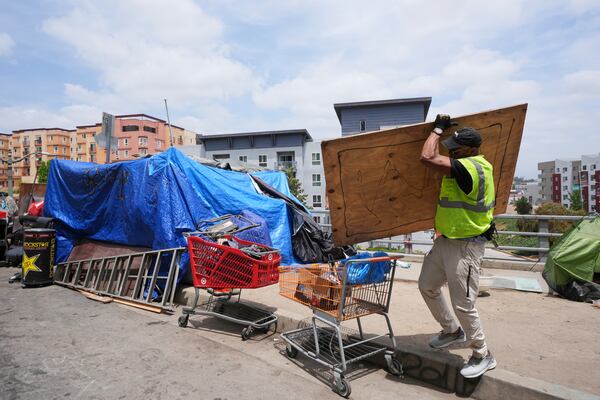 Jay Joshua cleans up around a homeless encampment where he currently lives, Monday, May 12, 2025, in Los Angeles. (AP Photo/Damian Dovarganes)
