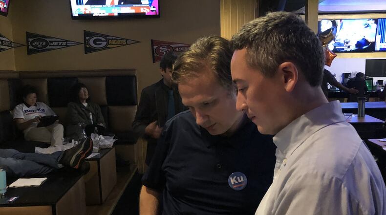 Ben Ku looks over local election results with campaign volunteer Charley Levinson during a watch party Tuesday night at Crowne Sports Bar. ARLINDA SMITH BROADY / ABROADY@AJC.COM