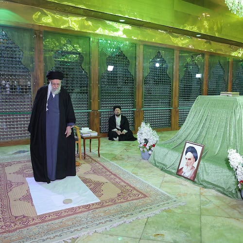 In this photo released by the official website of the office of the Iranian supreme leader, Supreme Leader Ayatollah Ali Khamenei prays at the grave of the late revolutionary founder Ayatollah Khomeini, shown in the photo at right, commemorating 47th anniversary of his return from exile during 1979 Islamic Revolution, as Ayatollah Khomeini's grandson Hassan sits at rear, just outside Tehran, Iran, Saturday, Jan. 31, 2026. (Office of the Iranian Supreme Leader via AP)