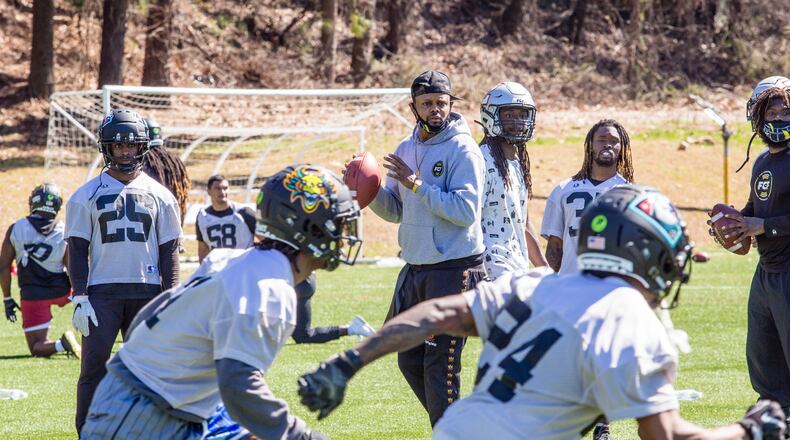 Fan Controlled Football professional Bones Bagaunte, center, runs plays at practice March 4, 2021 and is a league personality on the FCF broadcasts this season.  The FCF is in the middle of its first season with players and staff able to play and practice in their Covid-free bubble at the Silverbacks Field in Duluth.  The new league allows fans to interact, by calling plays during games, voting on trades weekly and participating in real-time online during live action.  (Jenni Girtman for The Atlanta Journal-Constitution)