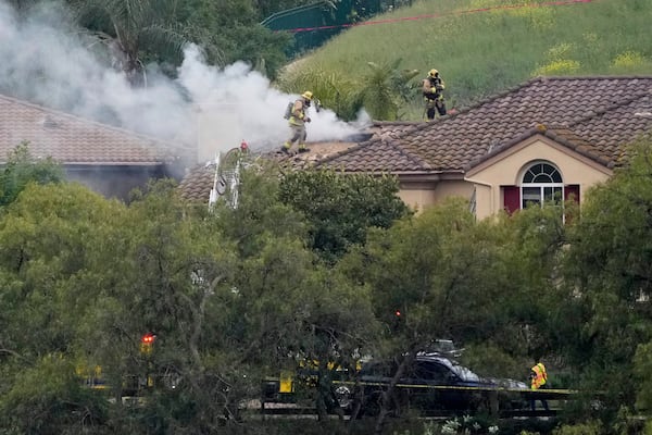 Firefighters work at the site of a plane crash in the Wood Ranch section of Simi Valley, Calif., on Saturday, May 3, 2025. (AP Photo/Mark J. Terrill)