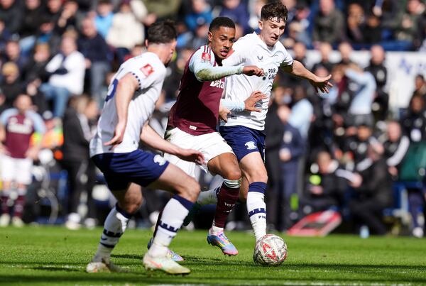 Aston Villa's Jacob Ramsey, center, breaks past Preston North End's Jordan Storey on their way to scoring their side's third goal of the game during the English FA Cup quarter final soccer match at Deepdale, Preston, England, Sunday, March 30, 2025. (Martin Rickett/PA via AP)