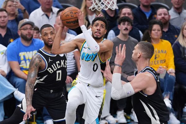 Indiana Pacers guard Tyrese Haliburton (0) shoots over Milwaukee Bucks center Brook Lopez (11) during the second half of a first-round NBA basketball playoff game in Indianapolis, Tuesday, April 22, 2025. (AP Photo/Michael Conroy)