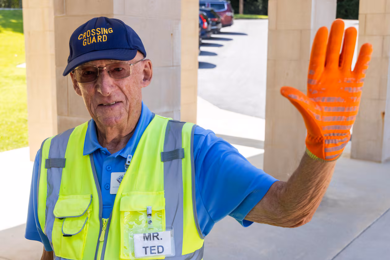Although the cold and rainy days aren't fun, “working at a grade school, you see the little guys, and it makes it all worthwhile,” said Ted Masters, the oldest school crossing guard in Peachtree City. (Phil Skinner for the AJC)