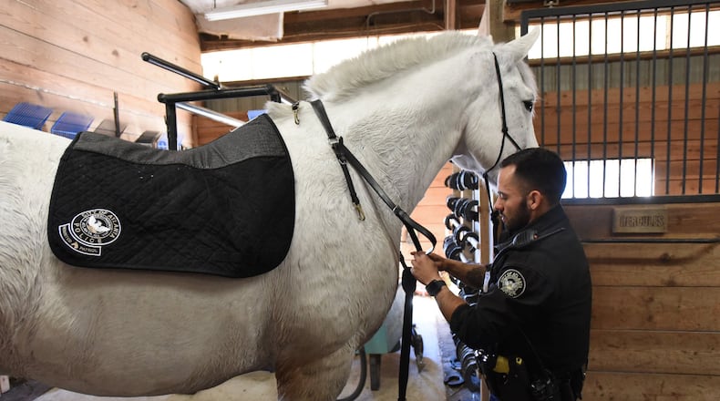 Officer Juan Restrepo prepares his patrol horse Hercules at the Atlanta Police Department's mounted patrol unit stables.