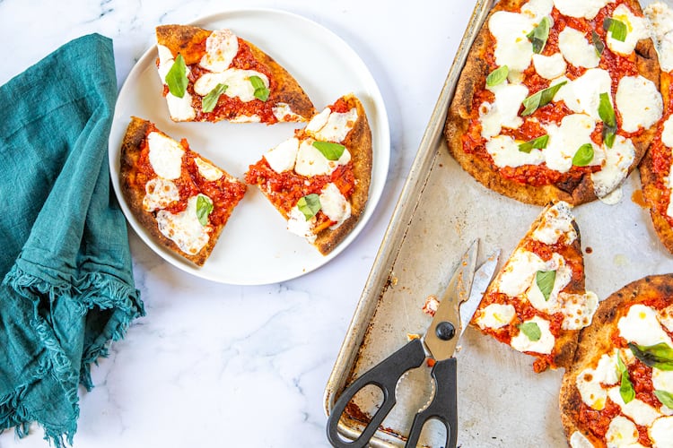 Naan provides a simple stand-in for the crust in homemade versions of the Bolognese pizza from Lloyd's Restaurant and Lounge in Inman Park. (Credit: Aaliyah Mann for the AJC, styling by Kate Itrich-Williams)