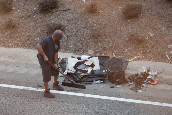 A worker clears debris from I-20's westbound lanes after a deadly crash near the Lee Street overpass early Wednesday, June 25, 2025. (Ben Hendren for the AJC)