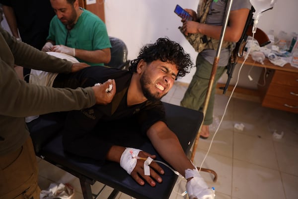 A Syrian government soldier who was injured in Sweida city during clashes between the Syrian government forces and Druze militias, receives treatment at a clinic in Busra al-Harir village, southern Syria, Tuesday, July 15, 2025. (AP Photo/Omar Albam)