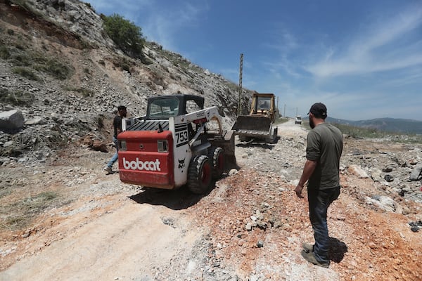 Workers close a crater following Israeli airstrikes that targeted hilltops near Nabatieh town, south Lebanon, Thursday, May 8, 2025. (AP Photo/Mohammed Zaatari)