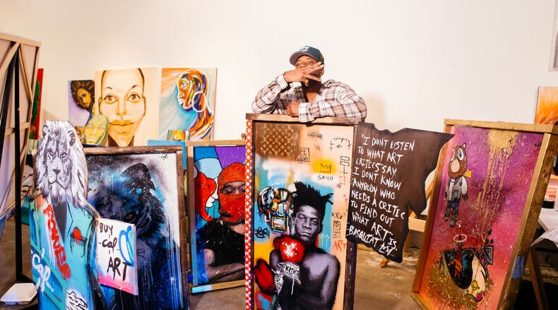 Pictured: Visual artist Cal Art stands with his creations at Black Boy Art Show