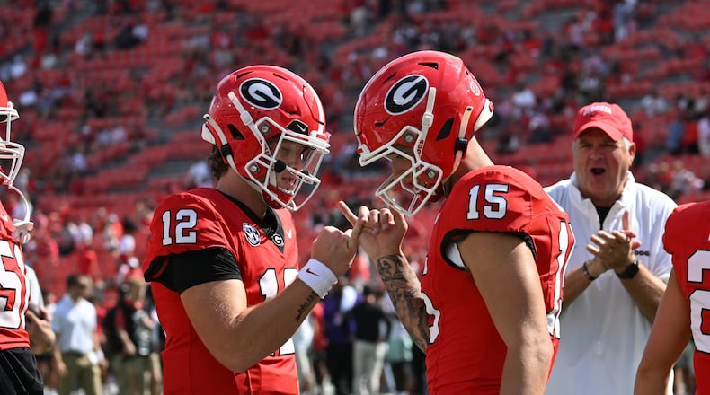 Georgia quarterback Ryan Puglisi (12) and quarterback Carson Beck (15) celebrate before an NCAA football game between Georgia and Auburn at Sanford Stadium, Saturday, October 5, 2024, in Athens. (Hyosub Shin / AJC)