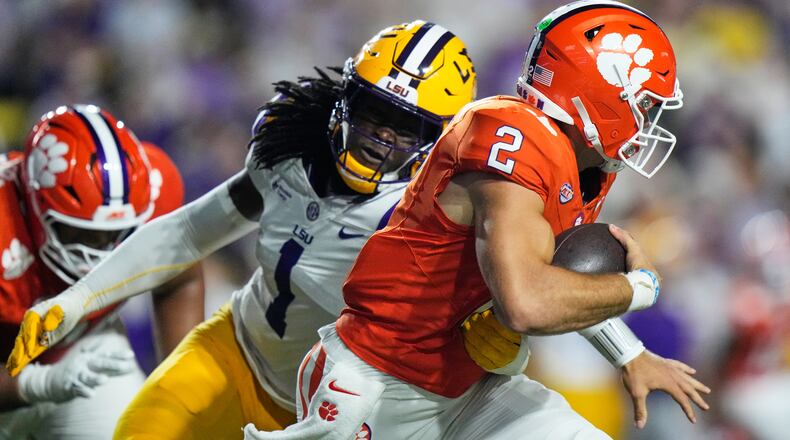Clemson quarterback Tait Reynolds (2) is sacked by LSU defensive end Princewill Umanmielen (1) in the first half of an NCAA college football game, Saturday, Sept. 5, 2026 in Baton Rouge, La. (AP Photo/Gerald Herbert)