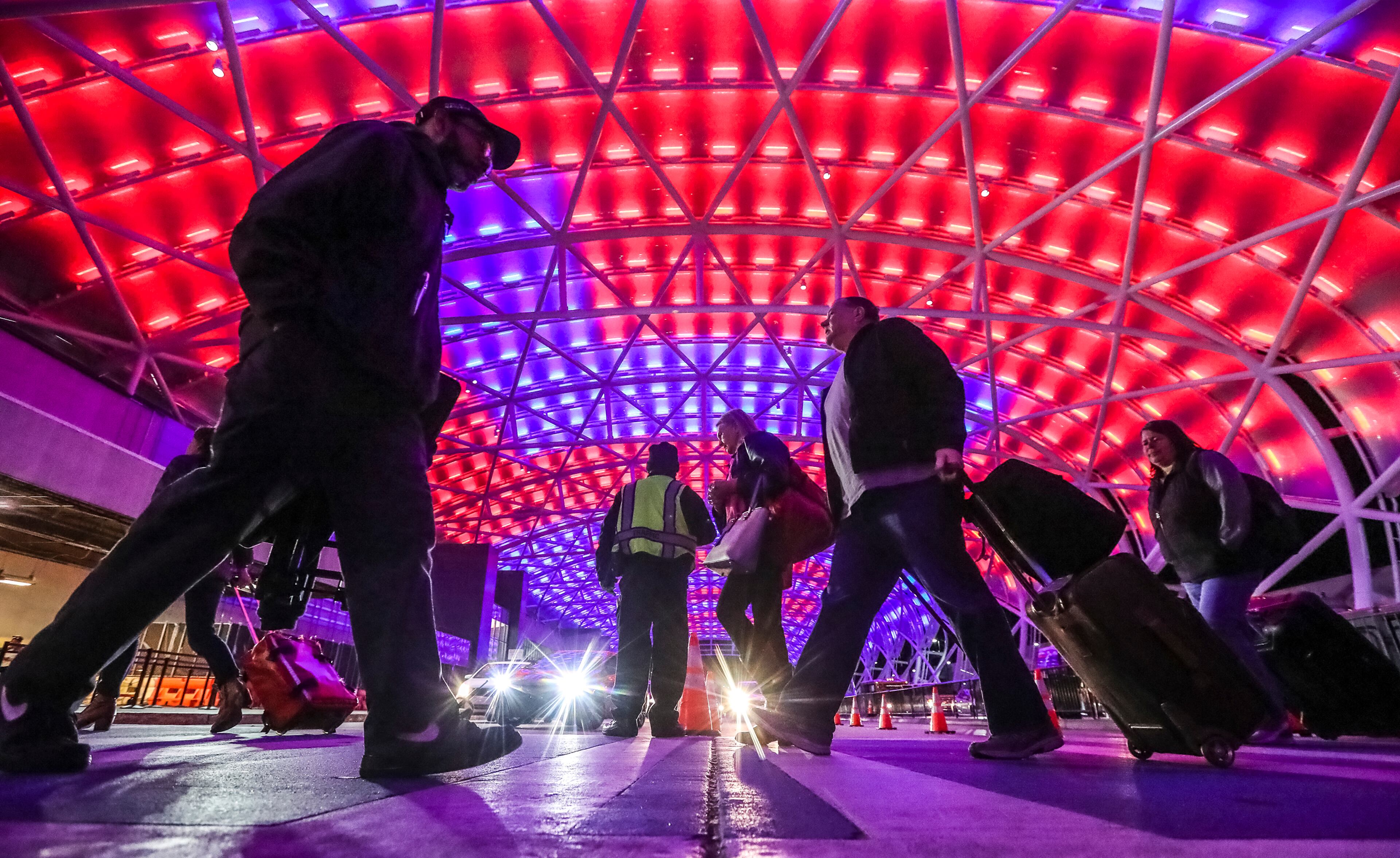 Passengers travel under the illuminated canopy of the North Terminal at Hartsfield-Jackson International Airport in Atlanta. The world's busiest airport was bustling with passengers arriving for the Super Bowl on Feb. 1, 2019.