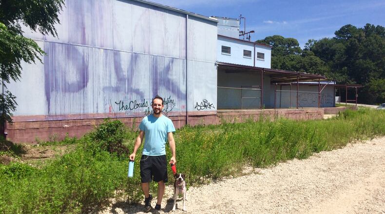 Avi Gelfond and his dog, Frankie, on a walk on the Beltline next to property that is getting a tax break for new apartments. “Why are they giving tax breaks for this property when our taxes are going up? It seems absurd,” Gelfond said. (Photo by Bill Torpy)