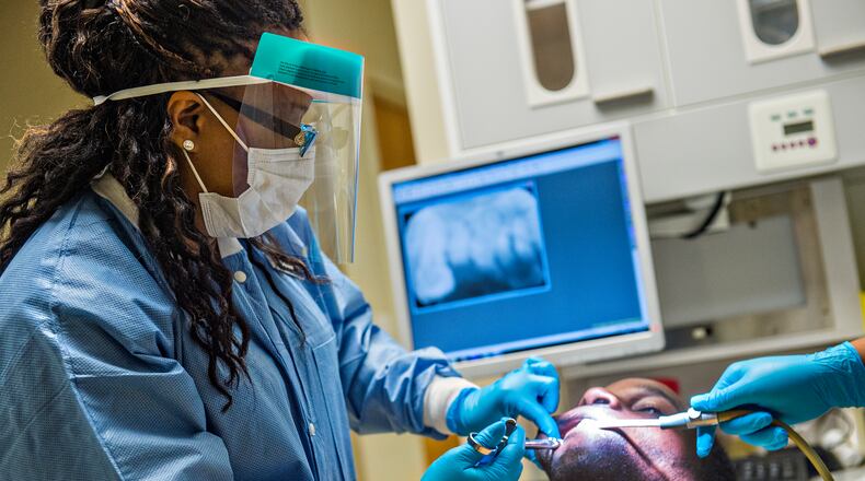Dr. Katrina Schuler-Bacon (left) gives Marcet Love a shot of numbing medication before pulling one of his teeth at the Mercy Care free dental clinic in Atlanta on Tuesday, May 19. Four and a half million Georgians lack dental insurance, and many of them haven’t seen a dentist in decades. JONATHAN PHILLIPS / SPECIAL