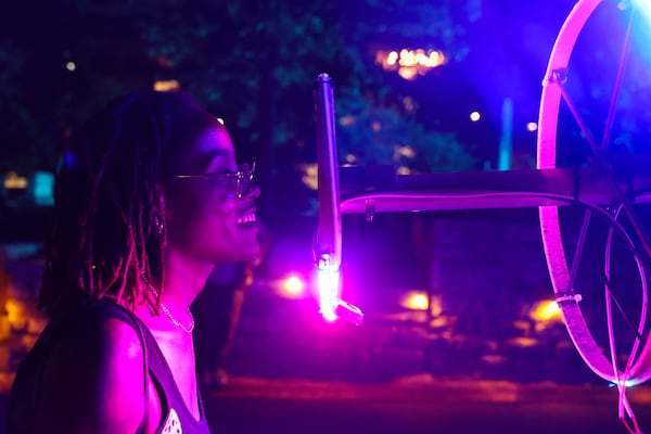 Latonya Beverly looks through a display at the Illumine exhibit at Oakland Cemetery in Atlanta on April 16, 2026. (Arvin Temkar/AJC)