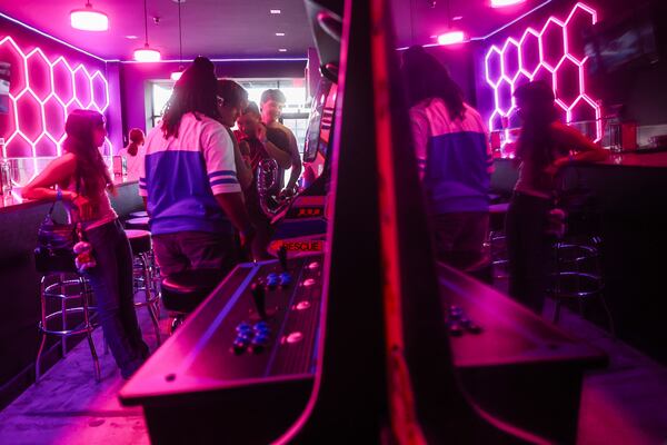 Zaria McKibbins (in blue and white shirt) and friends hang at Infinite Horizons Arcade. Underserved teens "are exactly who we had in mind as our target audience,” said Gwen Darby, general manager of the nearby Infinite Realities comic store also owned by Chris and Tiffany Brennaman. (Abbey Cutrer/AJC)