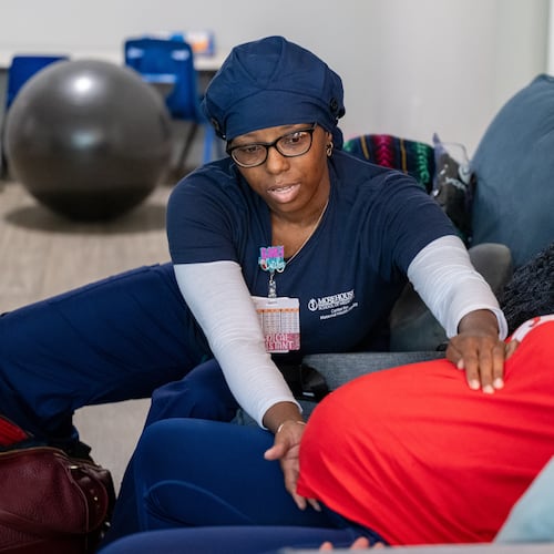 Doula Bashellia Williams (left) checks the position of her client, Reona Porter’s baby at Porter’s Stockbridge apartment on Friday, Oct. 8, 2024. Porter was just over 38 weeks pregnant. (Bita Honarvar for the AJC)