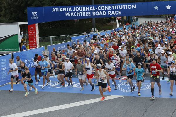 Early waves of runners take off during the 56th annual AJC Peachtree Road Race on Friday, July 4, 2025, in Atlanta. A MARTA train that broke down on a key part of the tracks caused a ripple effect of delays that kept some runners from arriving at the starting line on time. (Arvin Temkar/AJC)