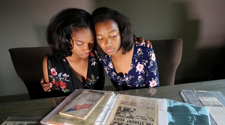 Twin sisters Sharena (left) and Malia Johnson, 17, of Lawrenceville put together a civil rights family heritage project they presented as Girl Scouts in 2011. (The notebook contains the historical documents they presented to supplement their project.) Their family has a place in the Mississippi Civil Rights Museum. CURTIS COMPTON / CCOMPTON@AJC.COM