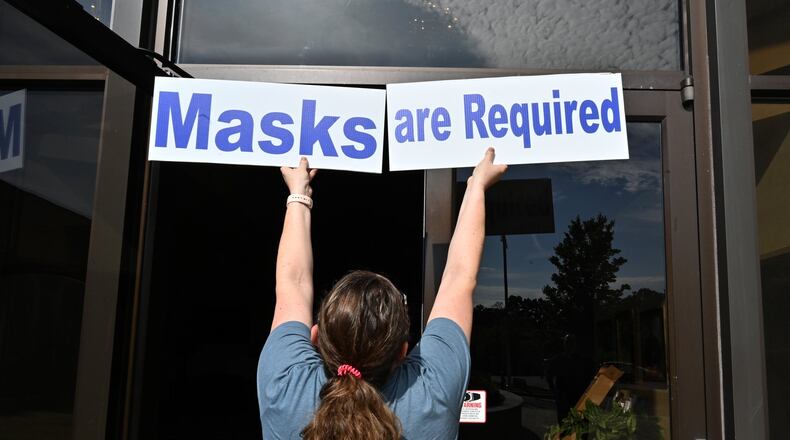 Mary Beth McKenna, director of religious education, checks a position for signs on Saturday, May 23, 2020, ahead of daily Mass resuming Monday, May 25, 2020, at St. Benedict Catholic Church. HYOSUB SHIN / HYOSUB.SHIN@AJC.COM