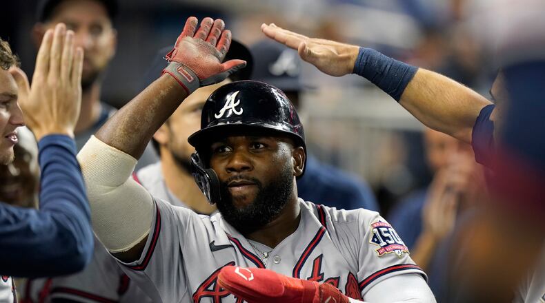 Atlanta Braves' Abraham Almonte celebrates with teammates after he scored on a single by Jorge Soler during the eighth inning of a baseball game against the Miami Marlins, Tuesday, Aug. 17, 2021, in Miami. (AP Photo/Wilfredo Lee)