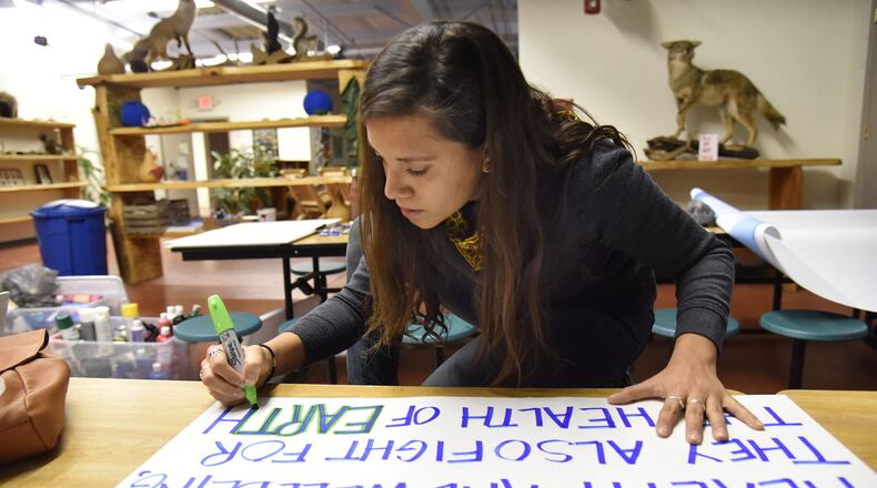 Marinangeles Gutierrez, who plans to participate in Saturday’s Women’s March on Washington, writes her message during a sign-making session Thursday at the Georgia Sierra Club. HYOSUB SHIN / HSHIN@AJC.COM