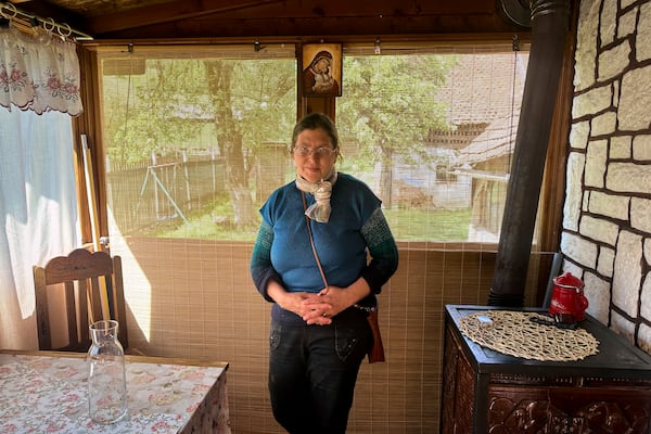 Liliana Cosurean, 54, stands in her home, in the village of Floresti, in Romania's central Transylvania region, Thursday, April 24, 2025. (AP Photo/Stephen McGrath)