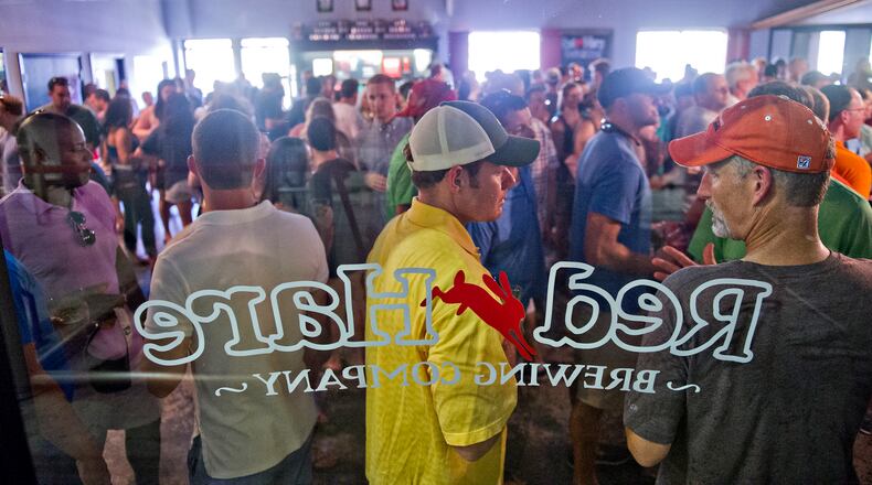 Mike Moseley (center) and Mike Smith (right) talk as they try different beers at Red Hare Brewery in Marietta during the company's third anniversary party on Saturday, August 23, 2014. JONATHAN PHILLIPS / SPECIAL