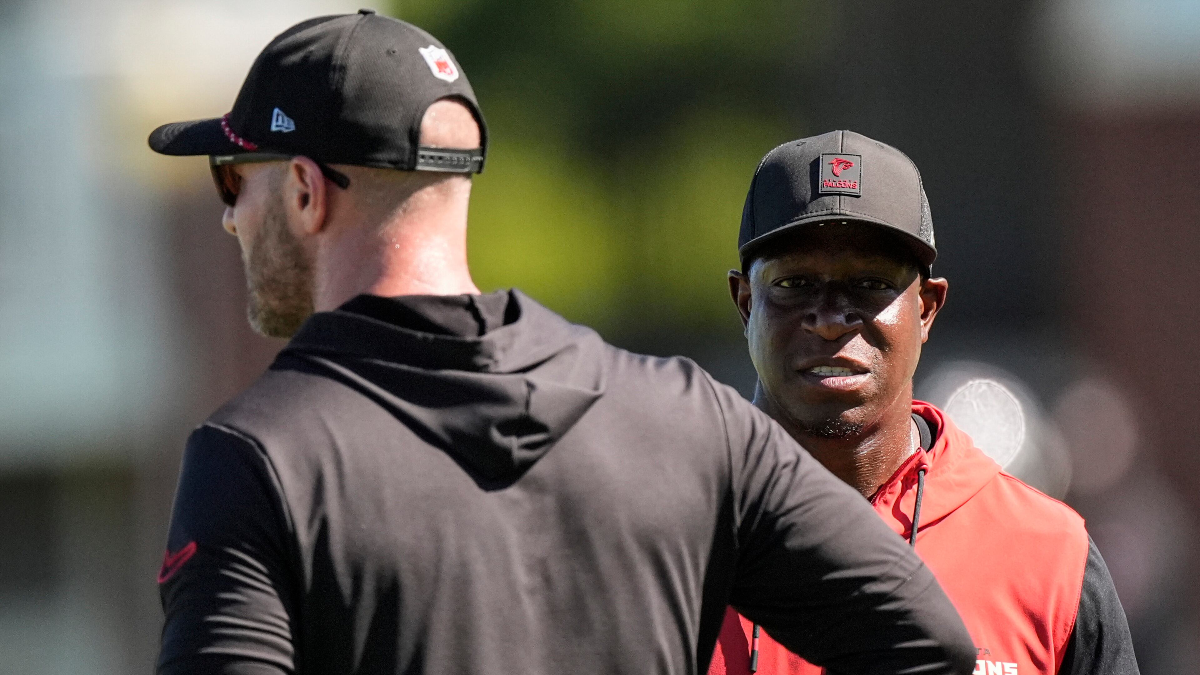 Atlanta Falcons head coach Raheem Morris, right, speaks with coach T. J. Lang during a Atlanta Falcons training camp, Saturday, July 26, 2025, in Flowery Branch. (AP Photo/Mike Stewart)