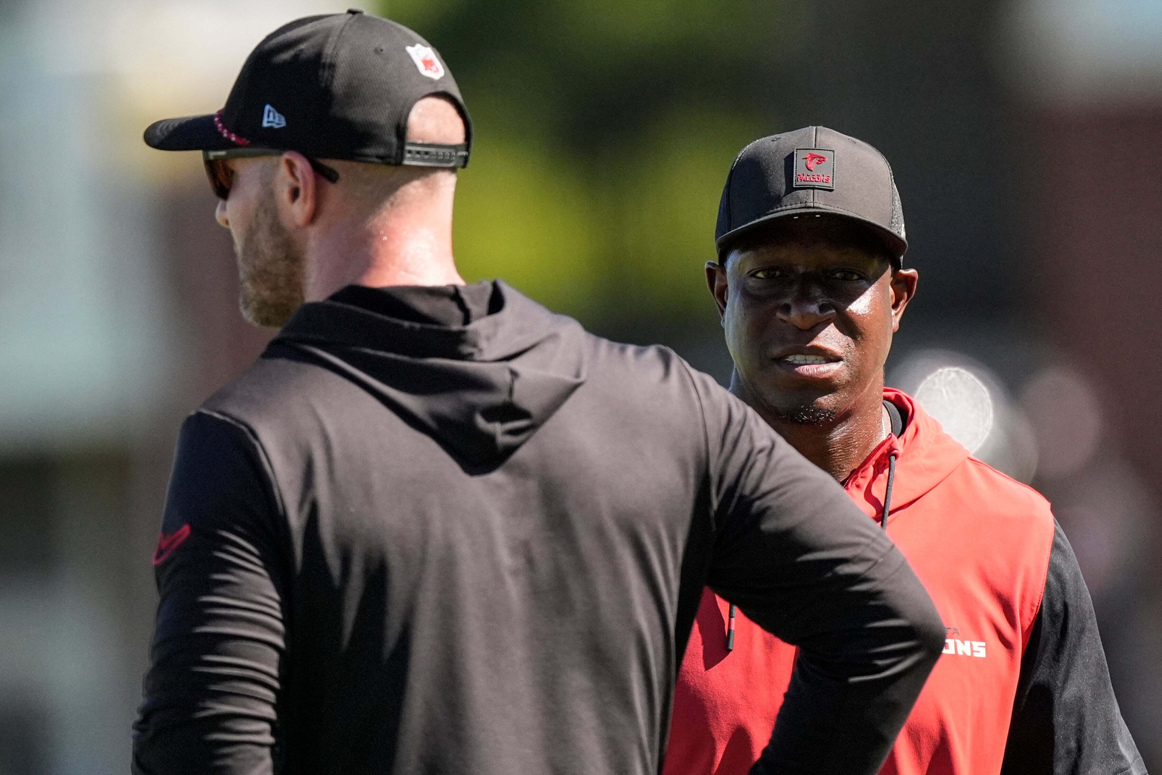 Atlanta Falcons head coach Raheem Morris, right, speaks with coach T. J. Lang during a Atlanta Falcons training camp, Saturday, July 26, 2025, in Flowery Branch. (AP Photo/Mike Stewart)