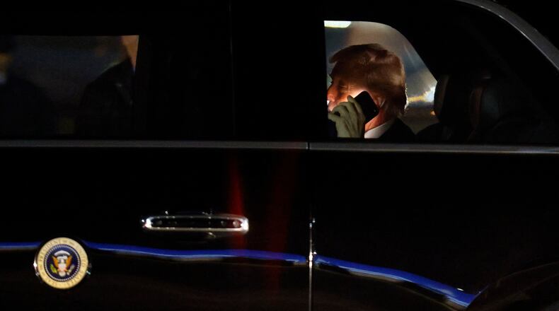 FILE - President Donald Trump talks on his cell phone in his limousine, known as "The Beast," upon his arrival at Joint Base Andrews, Md., March 6, 2026. (AP Photo/Luis M. Alvarez, File)