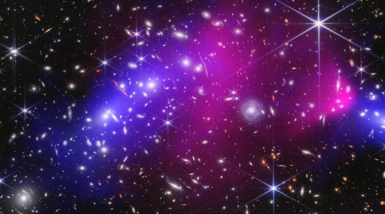 This NASA image shows two massive galaxy clusters previously captured by NASA's James Webb Space Telescope and Chandra X-ray Observatory, with areas of possible dark matter in blue. (NASA via AP)
