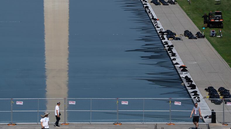 Workers install fireworks along the edge of the Lincoln Memorial Reflecting Pool ahead of the America 250 July 4th celebration on the National Mall, Thursday, July 2, 2026, in Washington. (AP Photo/Nathan Howard)