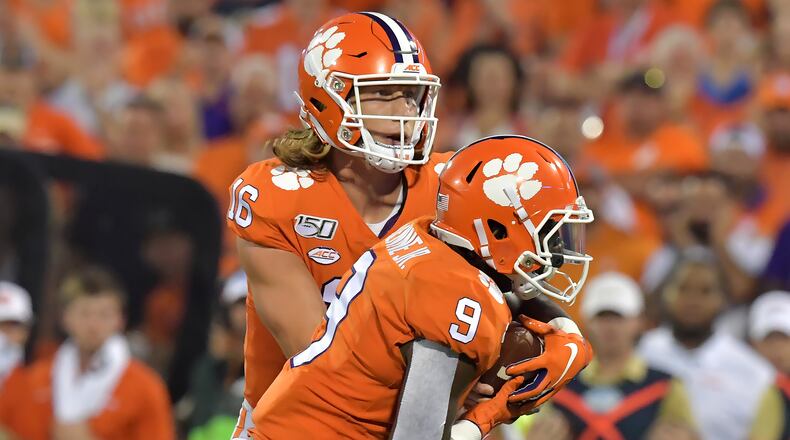 Clemson quarterback Trevor Lawrence (16) fakes hand-off to Clemson running back Travis Etienne (9) and then runs for a touchdown in the first half at Memorial Stadium on the Clemson University campus in Clemson, S.C. on Thursday, August 29, 2019. Georgia Tech took the field for the first time with Geoff Collins as head coach. (Hyosub Shin / Hyosub.Shin@ajc.com)