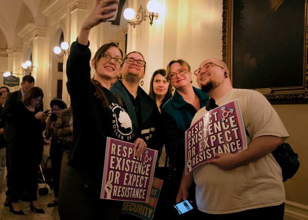 Opponents take a selfie outside hearing to consider bills to pass rules banning transgender student-athletes Tuesday, April 1, 2025, in Sacramento, Calif. (AP Photo/Yuri Avila)