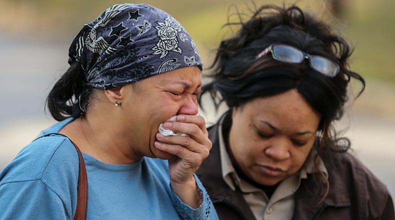 Jennifer Haggins grieves (left) as Micheldia Jones comforts her after she learned of the deaths of her friends. Two women and four men were killed early Monday, March 7, 2016, in a house fire in northwest Atlanta. JOHN SPINK / JSPINK@AJC.COM