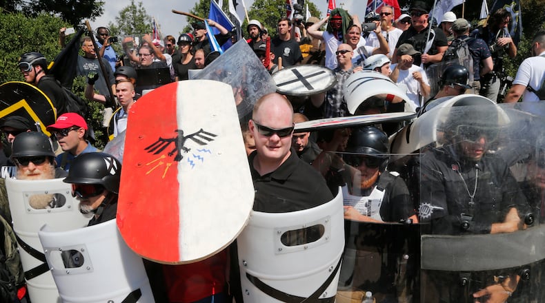 White nationalist demonstrators use shields as they guard the entrance to Lee Park in Charlottesville, Va., Saturday, Aug. 12, 2017. (AP Photo/Steve Helber)
