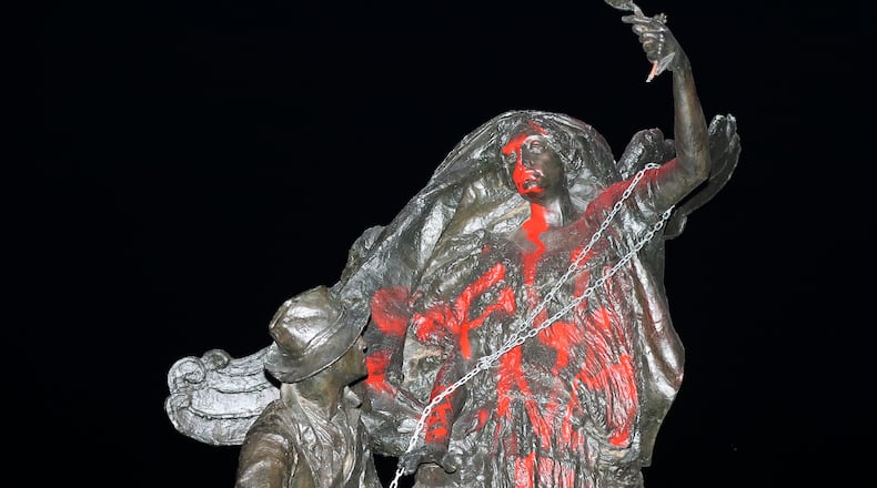 August 13, 2017 Atlanta: Protesters marching from Woodruff Park to Piedmont Park during a anti white nationalism memorial and march in response to violence in Virginia, spray painted and tried to topple a Confederate monument with a chain on Sunday, August 13, 2017, in Atlanta. The peace monument at the 14th Street entrance depicts a angel of peace stilling the hand of a Confederate soldier about to fire his rifle. Curtis Compton/ccompton@ajc.com